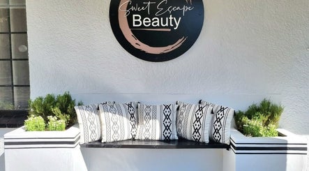 Inviting seating area at Sweet Escape Beauty, Sandton, Gauteng, ZA adorned with patterned cushions.