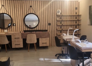 Modern nail salon at Sweet Escape Beauty, Sandton, Gauteng, ZA, featuring stylish wooden decor and round mirrors.
