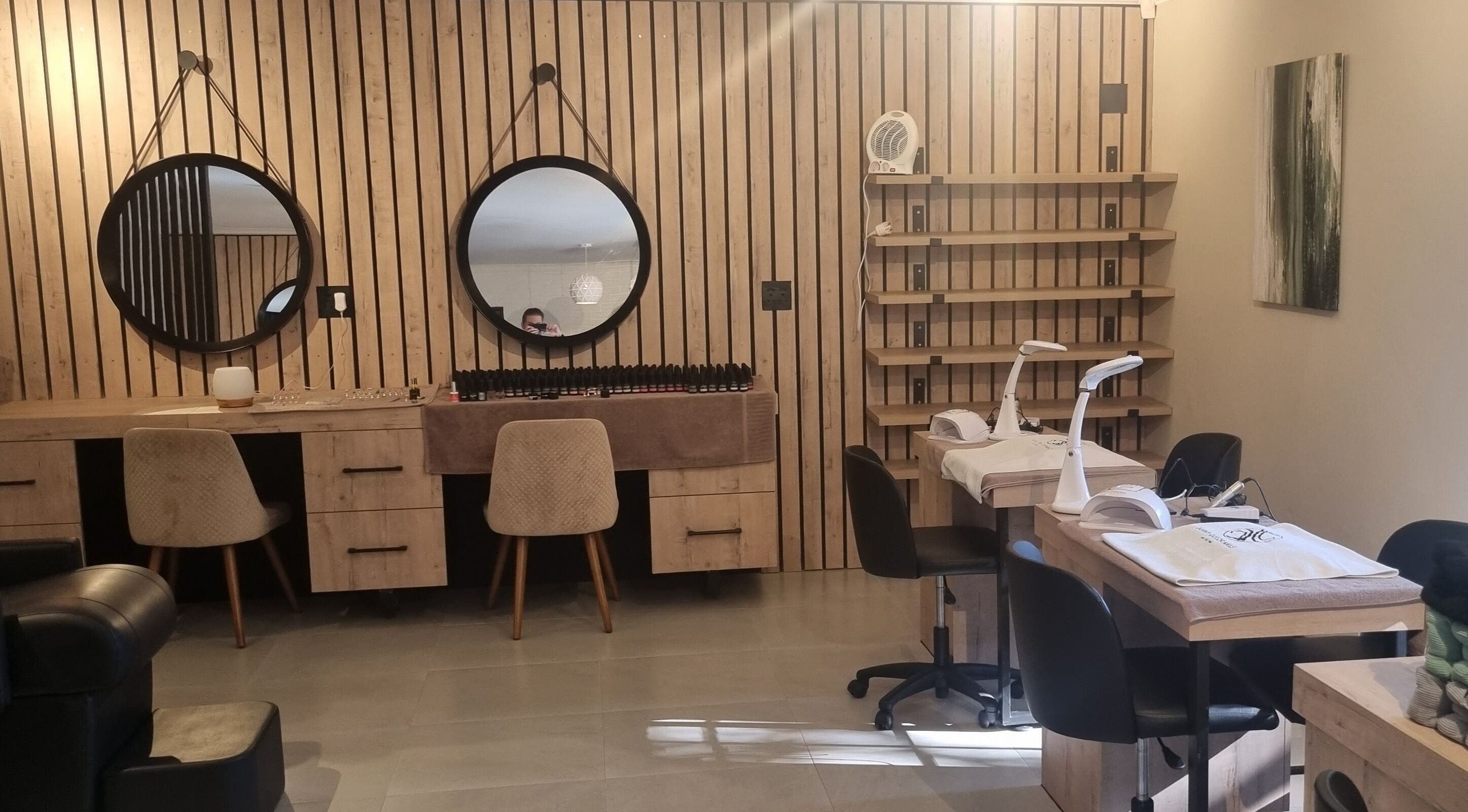 Modern nail salon at Sweet Escape Beauty, Sandton, Gauteng, ZA, featuring stylish wooden decor and round mirrors.