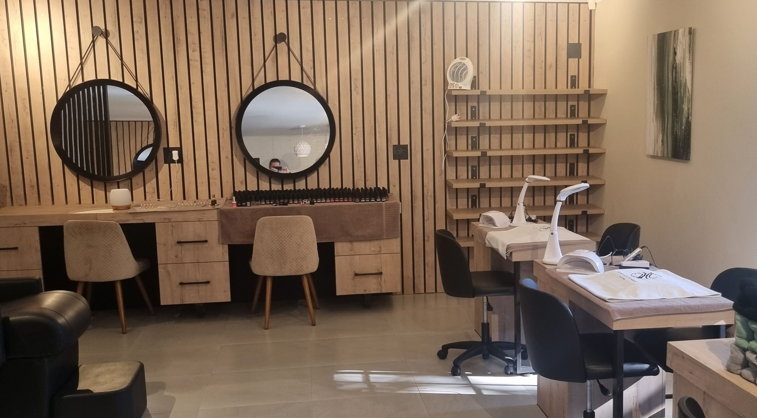 Modern nail salon at Sweet Escape Beauty, Sandton, Gauteng, ZA, featuring stylish wooden decor and round mirrors.