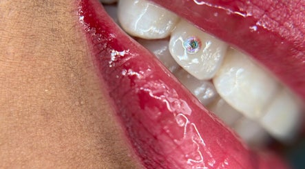 Detalle de labio rojo brillante con diente decorado en sstonegemss, Barcelona, Catalunya, ES.