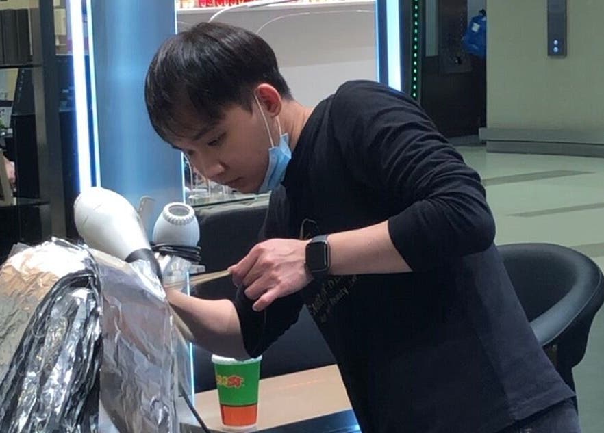 Stylist at Hair by Clement, Sydney, New South Wales, AU, expertly working on hair treatment.