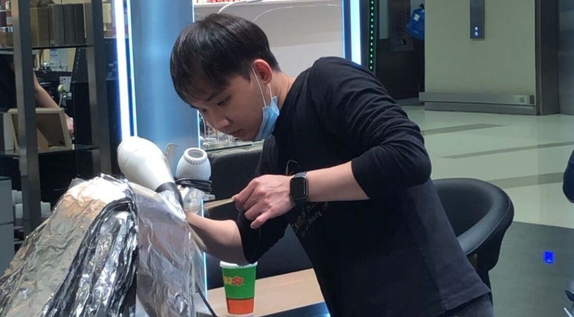 Stylist at Hair by Clement, Sydney, New South Wales, AU, expertly working on hair treatment.