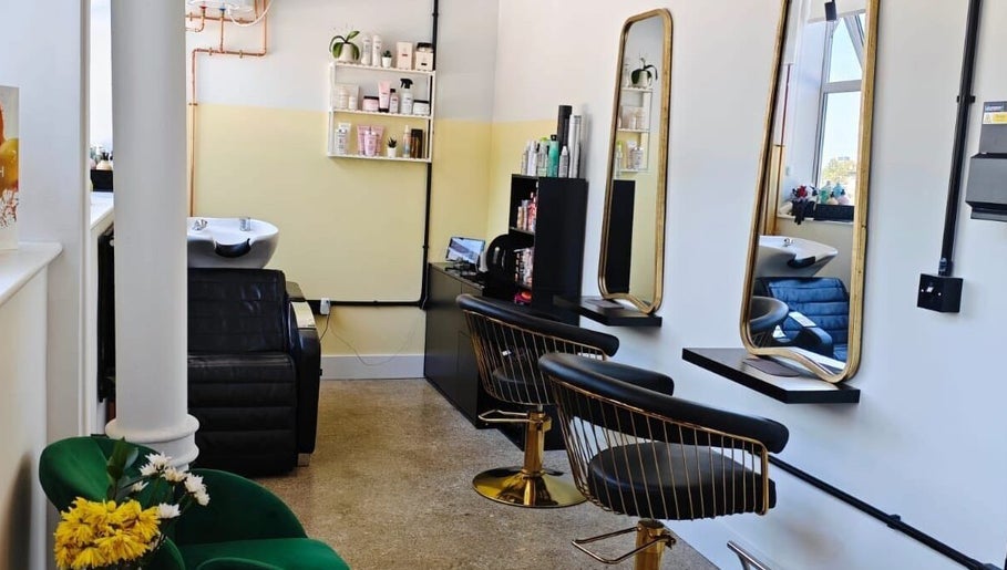 Elegant salon interior at Louis Does Hair in London, England, GB showcasing stylish chairs and mirrors.