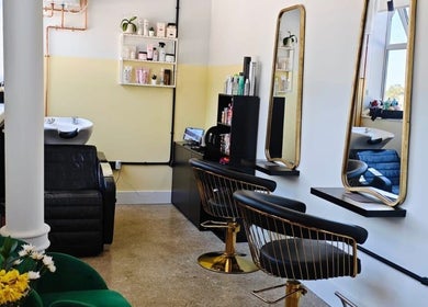Elegant salon interior at Louis Does Hair in London, England, GB showcasing stylish chairs and mirrors.