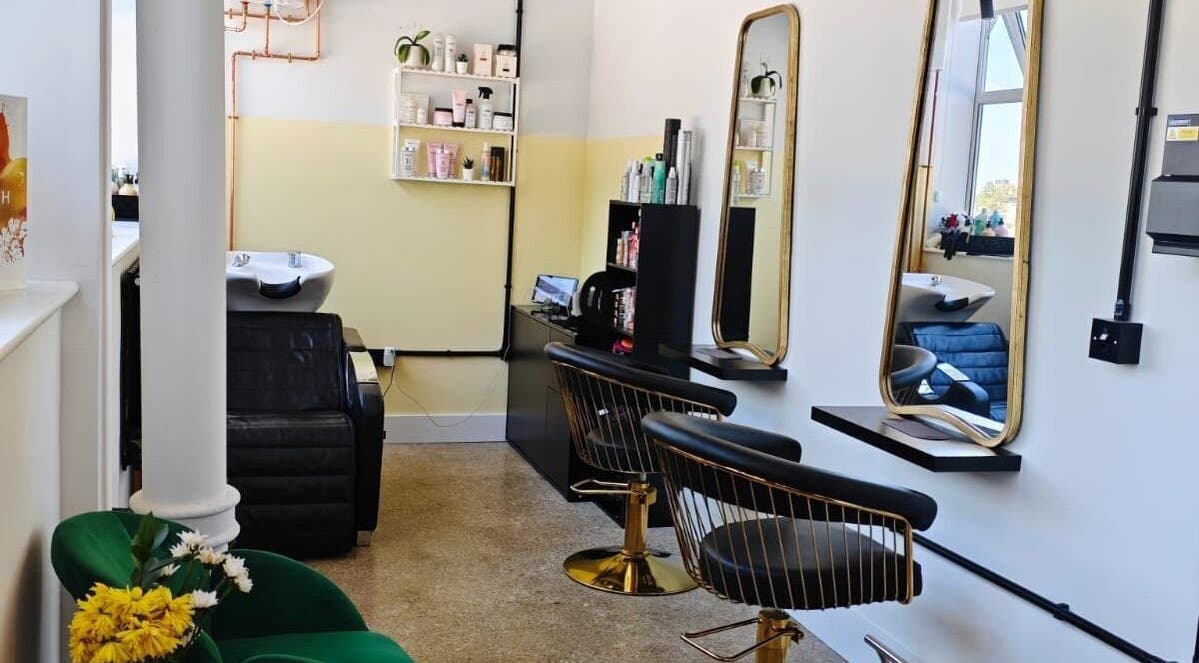Elegant salon interior at Louis Does Hair in London, England, GB showcasing stylish chairs and mirrors.