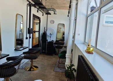 Stylish interior of Louis Does Hair salon, London, England, GB with modern decor and elegant mirrors.