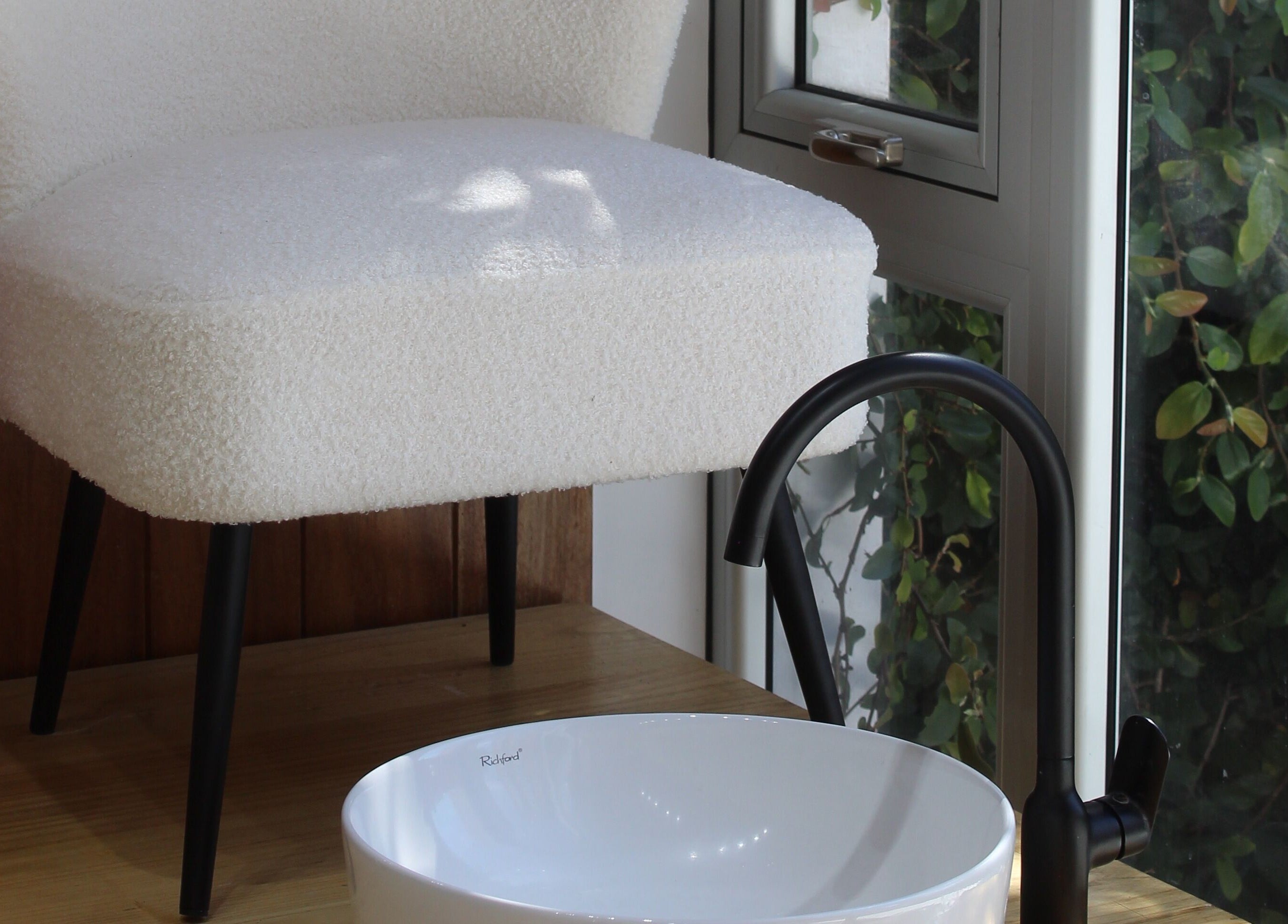 Rincón relajante en Sugar Hands, Ciudad De Guatemala, con silla blanca y lavabo moderno.