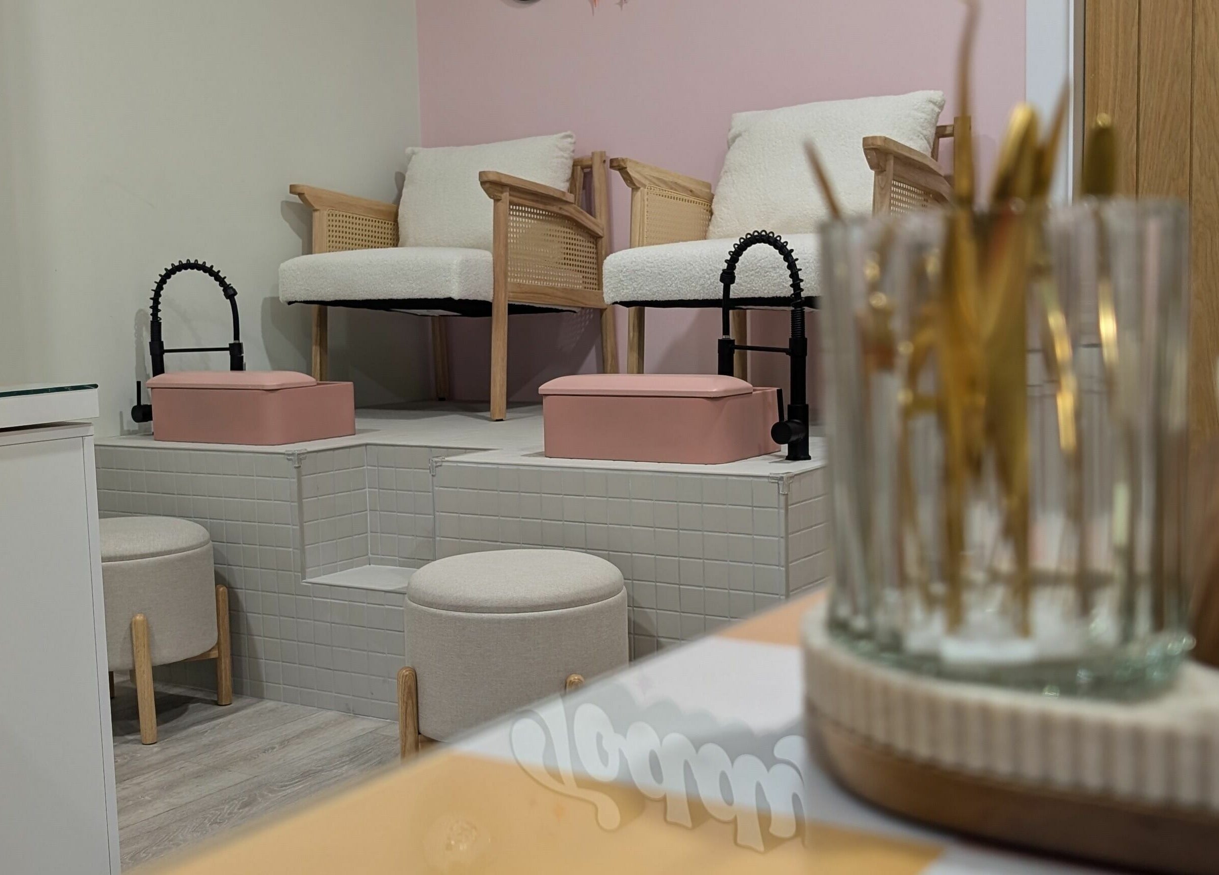 Spa seating area at Toddy's Nails Wadebridge, Wadebridge, England, GB with pink accents and cozy chairs.