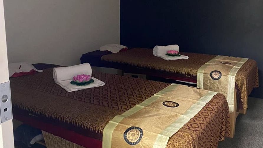 Calming massage room at Belmont Thai Massage Station, Auckland, NZ, featuring inviting decor and twin tables.