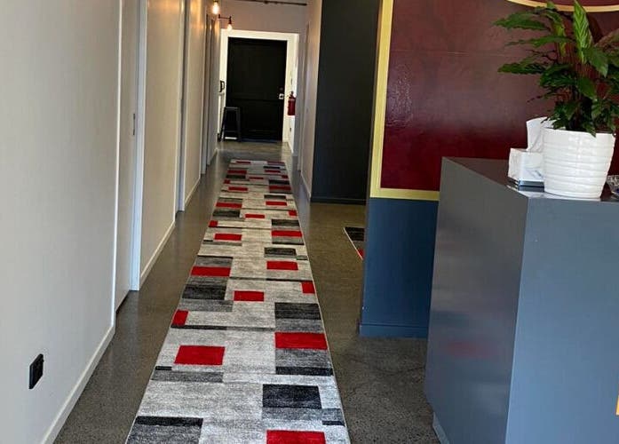 Elegant corridor at Belmont Thai Massage Station, Auckland, NZ with modern decor and vibrant carpet.
