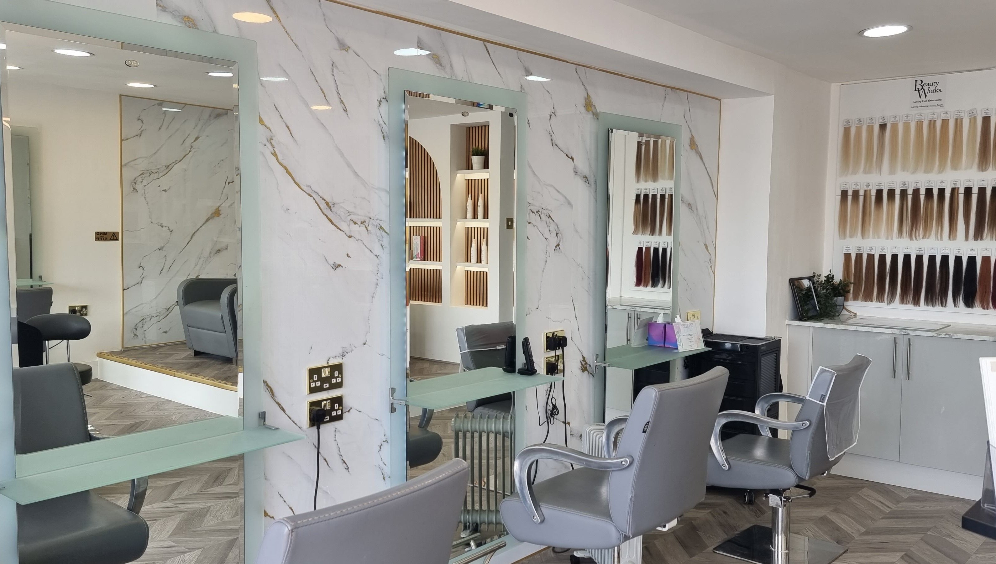 Elegant salon at HairArt_bydennileigh in Eccles, England, GB with mirrors and hair extension display.