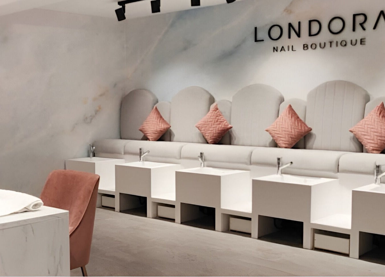 Chic interior of Londora Nail Boutique in London, England, GB with stylish nail stations and pink accents.