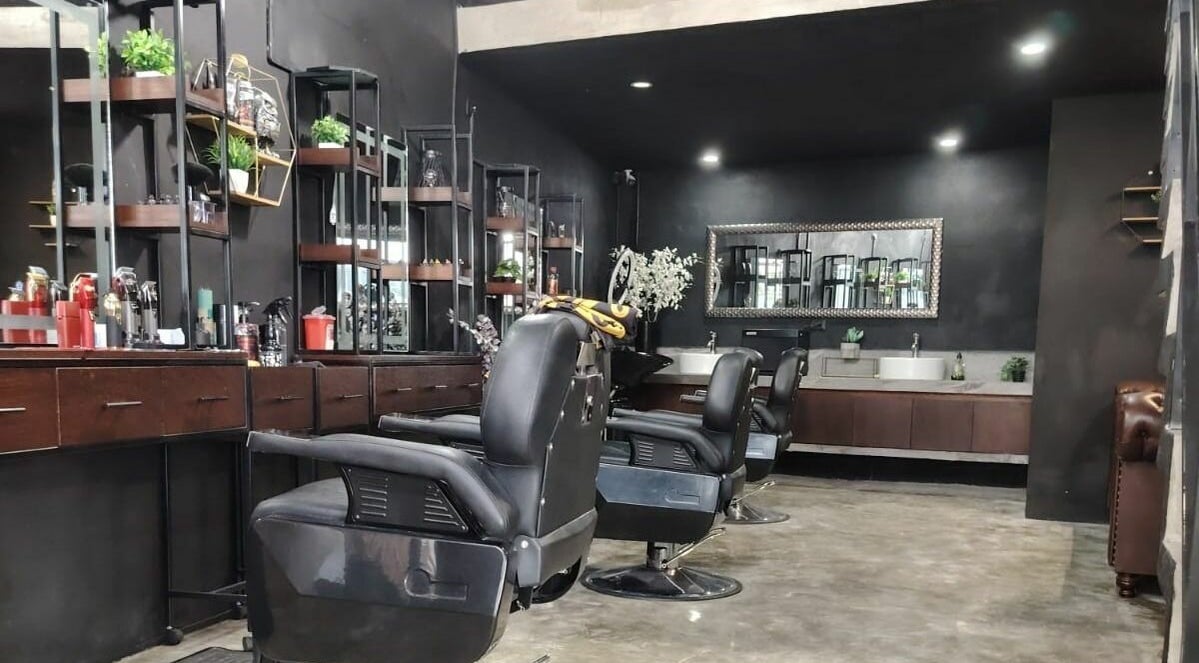 Moderno interior de SIR. PEREZ BARBERSHOP & INK en Conkal, Yucatán, MX con elegantes sillas de barbero.