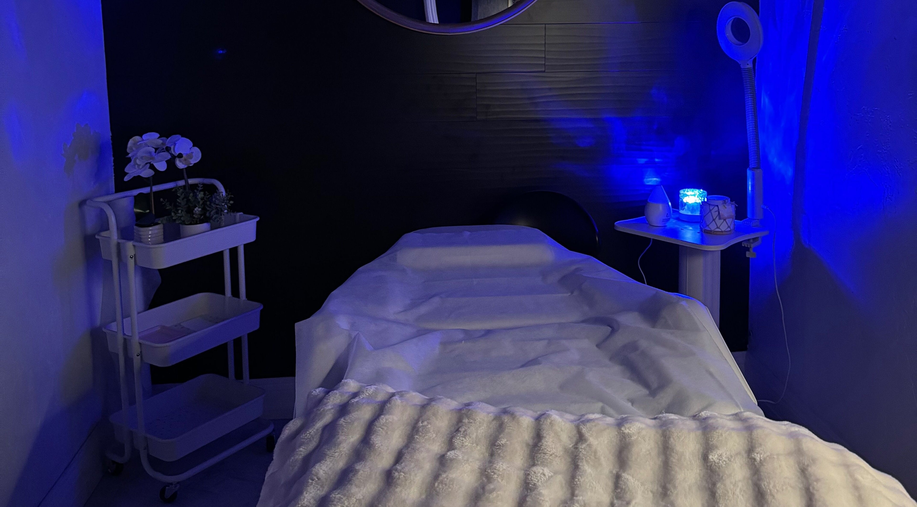 Tranquil treatment room at Leghecy Beauty Salon in Costa Mesa, California, US, with calming blue lighting.