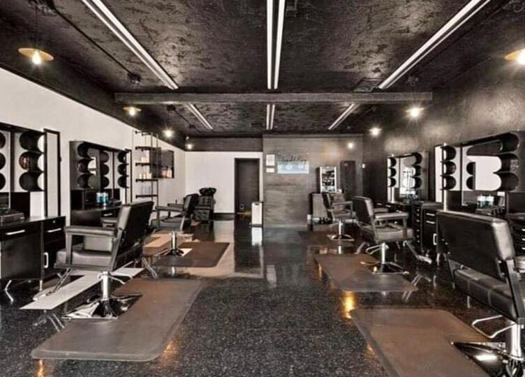 Modern salon at Leghecy Beauty Salon, Costa Mesa, California, US showcasing stylish black decor and seating.