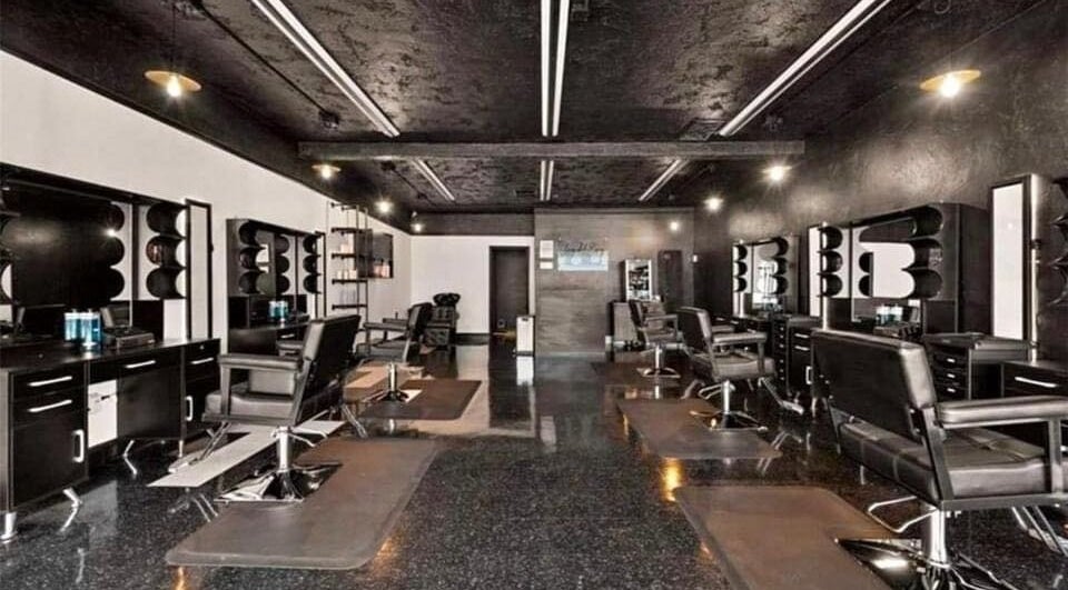 Modern salon at Leghecy Beauty Salon, Costa Mesa, California, US showcasing stylish black decor and seating.