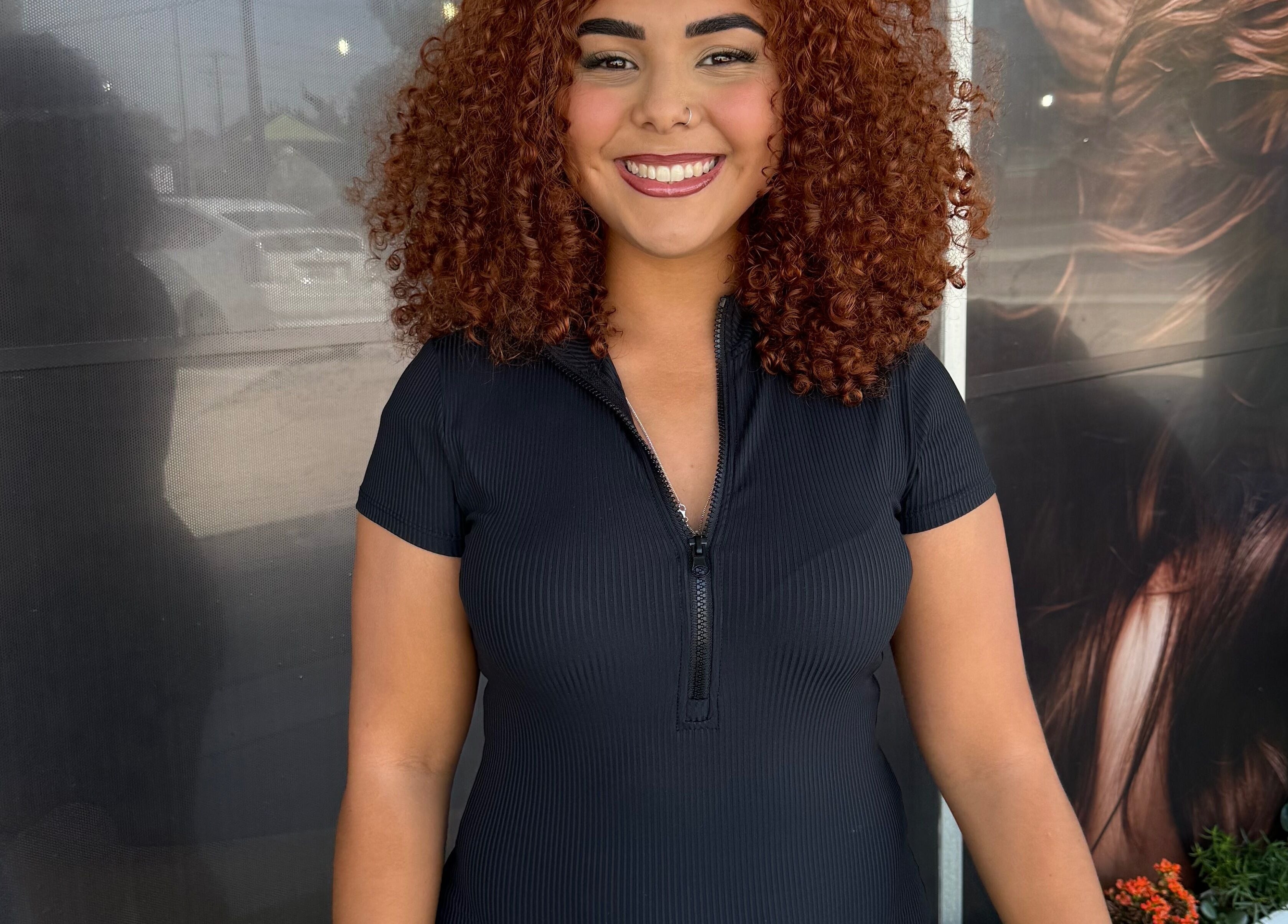 Smiling guest at Leghecy Beauty Salon in Costa Mesa, California, US, showcasing curly hairstyle.
