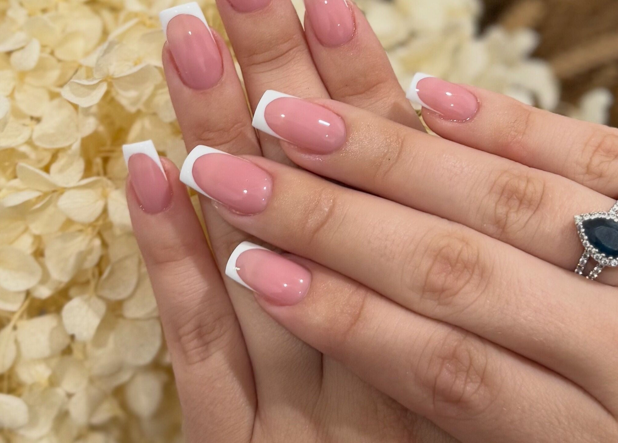 Beautiful French manicure at A Nail Artistry in Casula, New South Wales, AU with a delicate floral background.