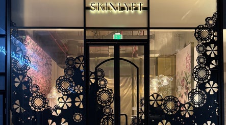 Front entrance of Skinlyft, an elegant beauty space in Dubai with decorative patterns and warm lighting.
