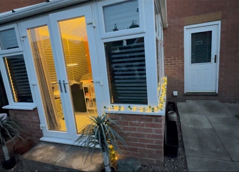 The Vines Of Beauty in Leeds, England, GB warmly lit entrance with potted plants and fairy lights.