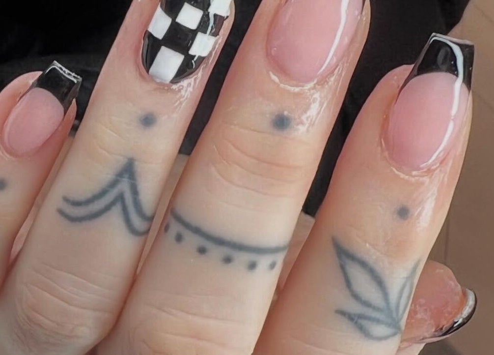 Stylish nail art with black French tips and tattoos at Vip Nails By Wafa, Glasgow, Scotland, GB.