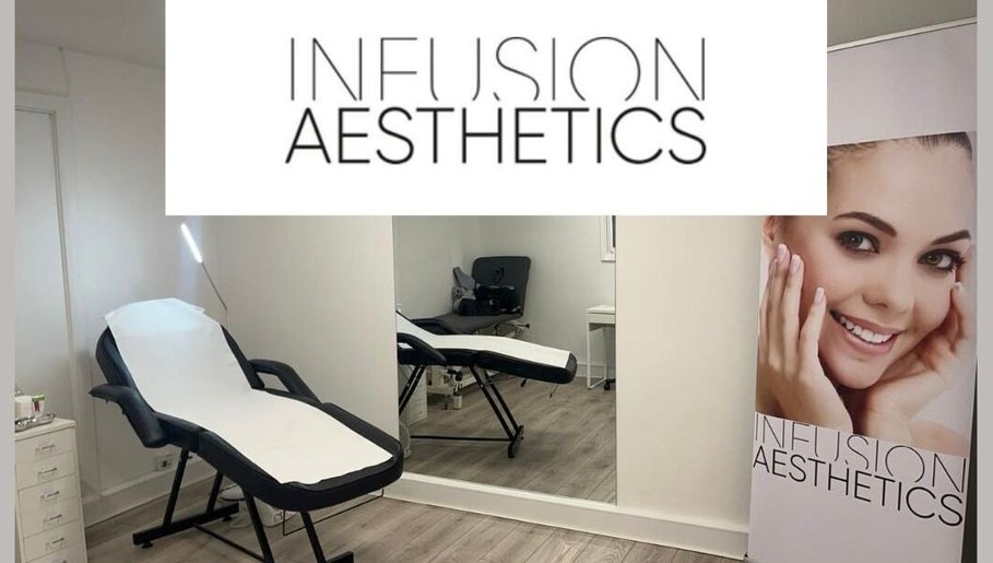Modern treatment room at Infusion Aesthetics UT Clinic, Burgess Hill, GB, featuring a sleek massage bed and mirror.