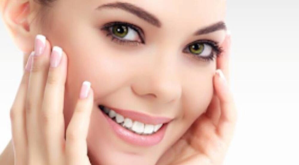 Smiling woman showcasing radiant skin at Infusion Aesthetics, Burgess Hill, England, GB.