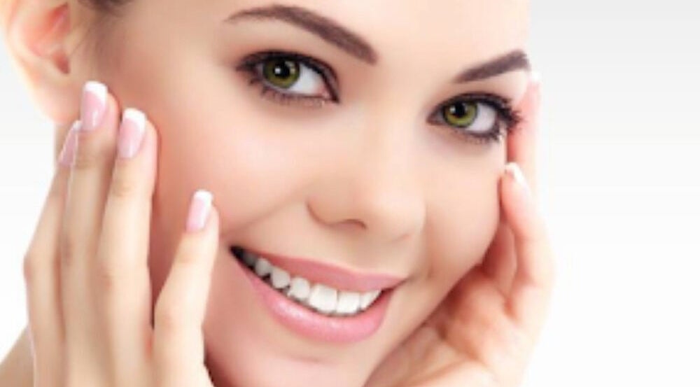 Smiling woman showcasing radiant skin at Infusion Aesthetics, Burgess Hill, England, GB.