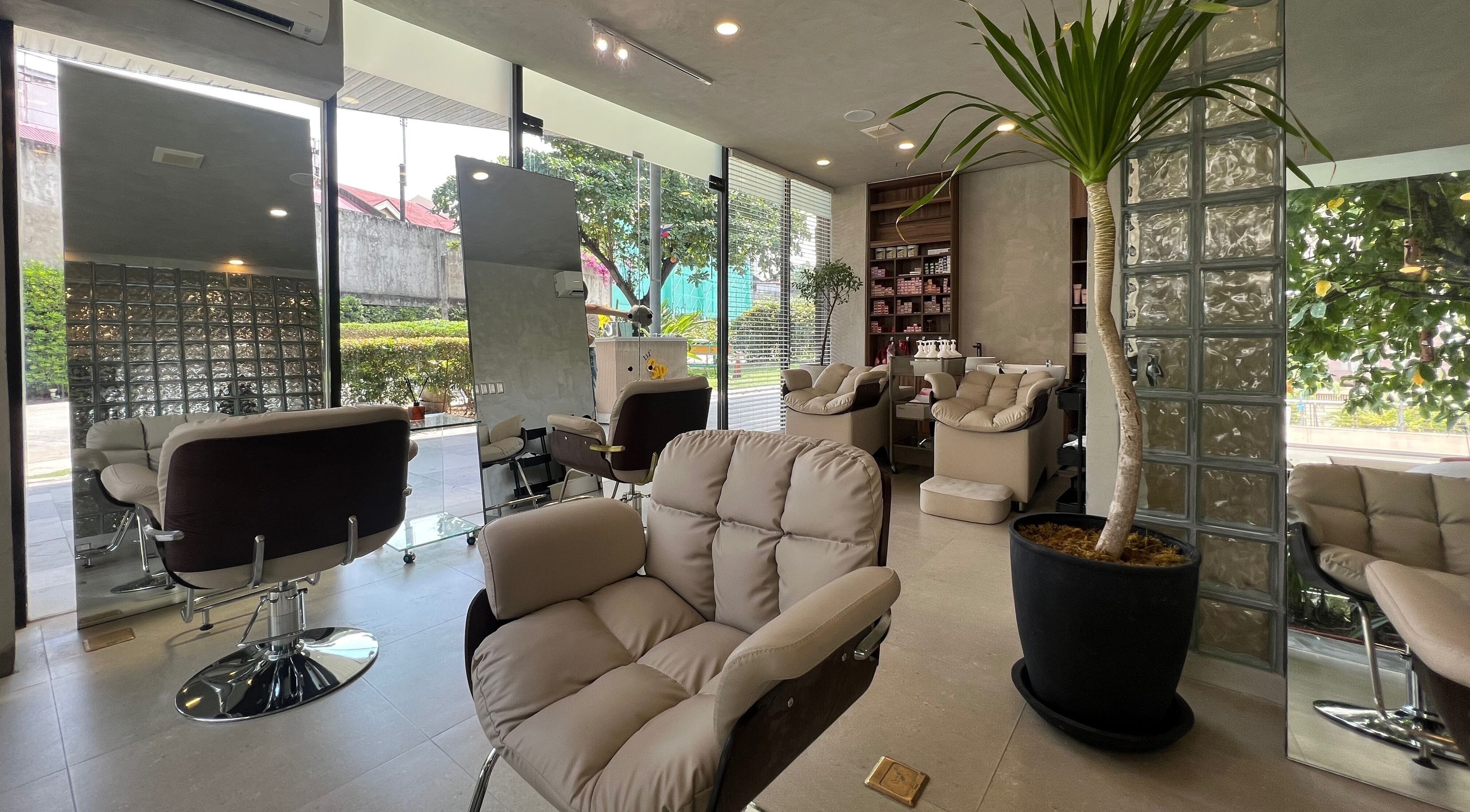 Modern interior of Ku Haku Japanese Hair Salon in Cebu City, Central Visayas, PH with lush greenery and plush chairs.