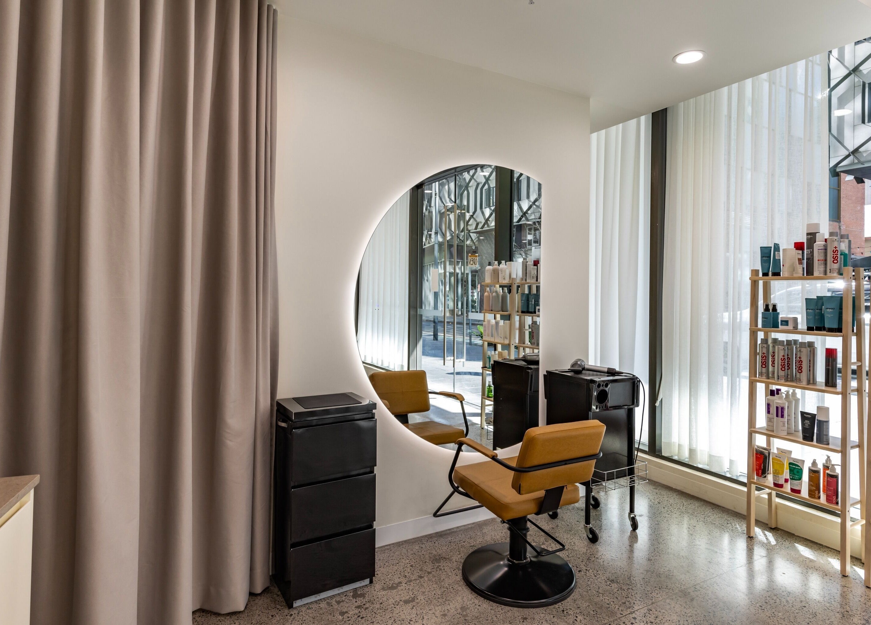 Modern styling chair and mirror at Project Hair Salon in Chippendale, NSW, AU with products displayed nearby.