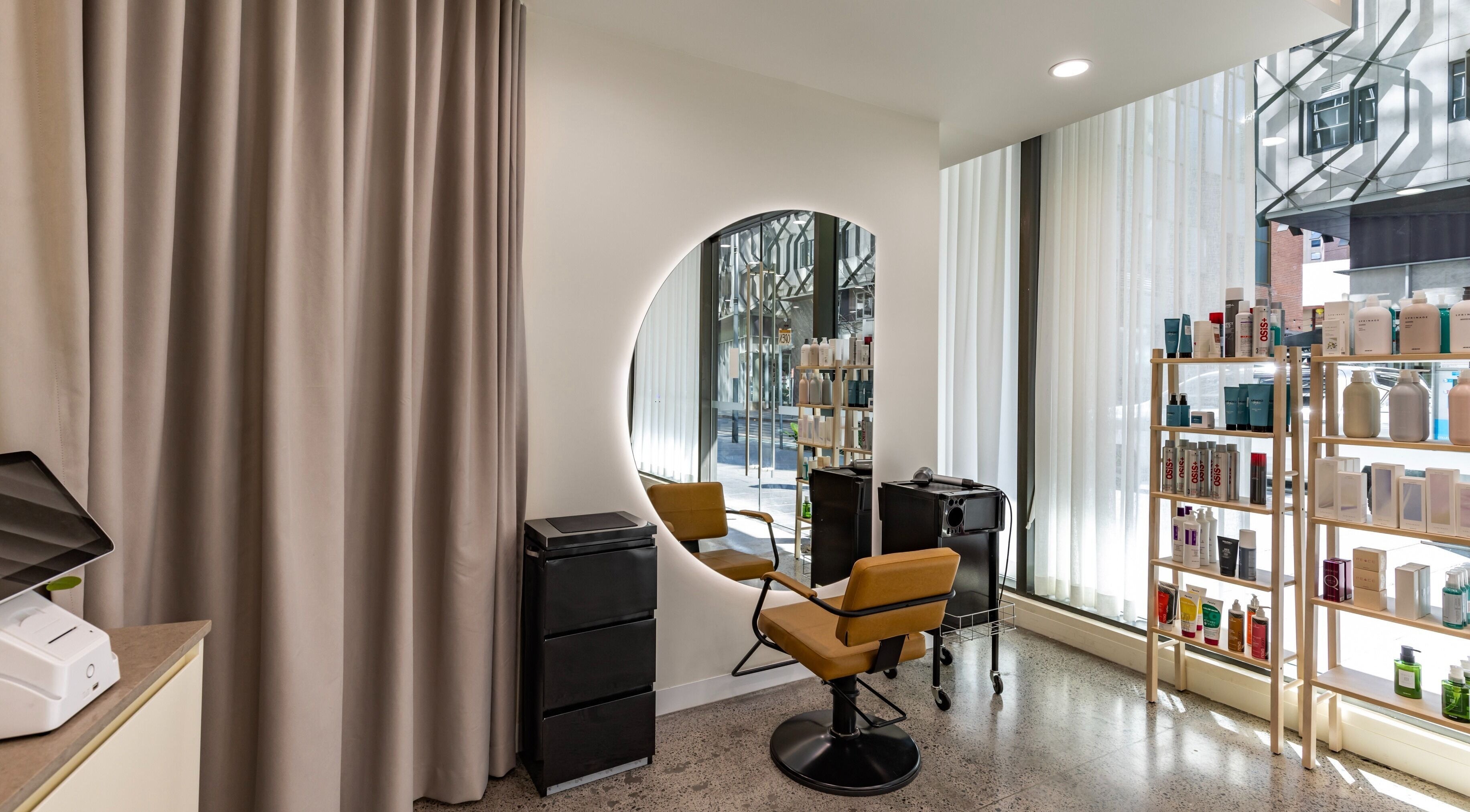 Modern styling chair and mirror at Project Hair Salon in Chippendale, NSW, AU with products displayed nearby.