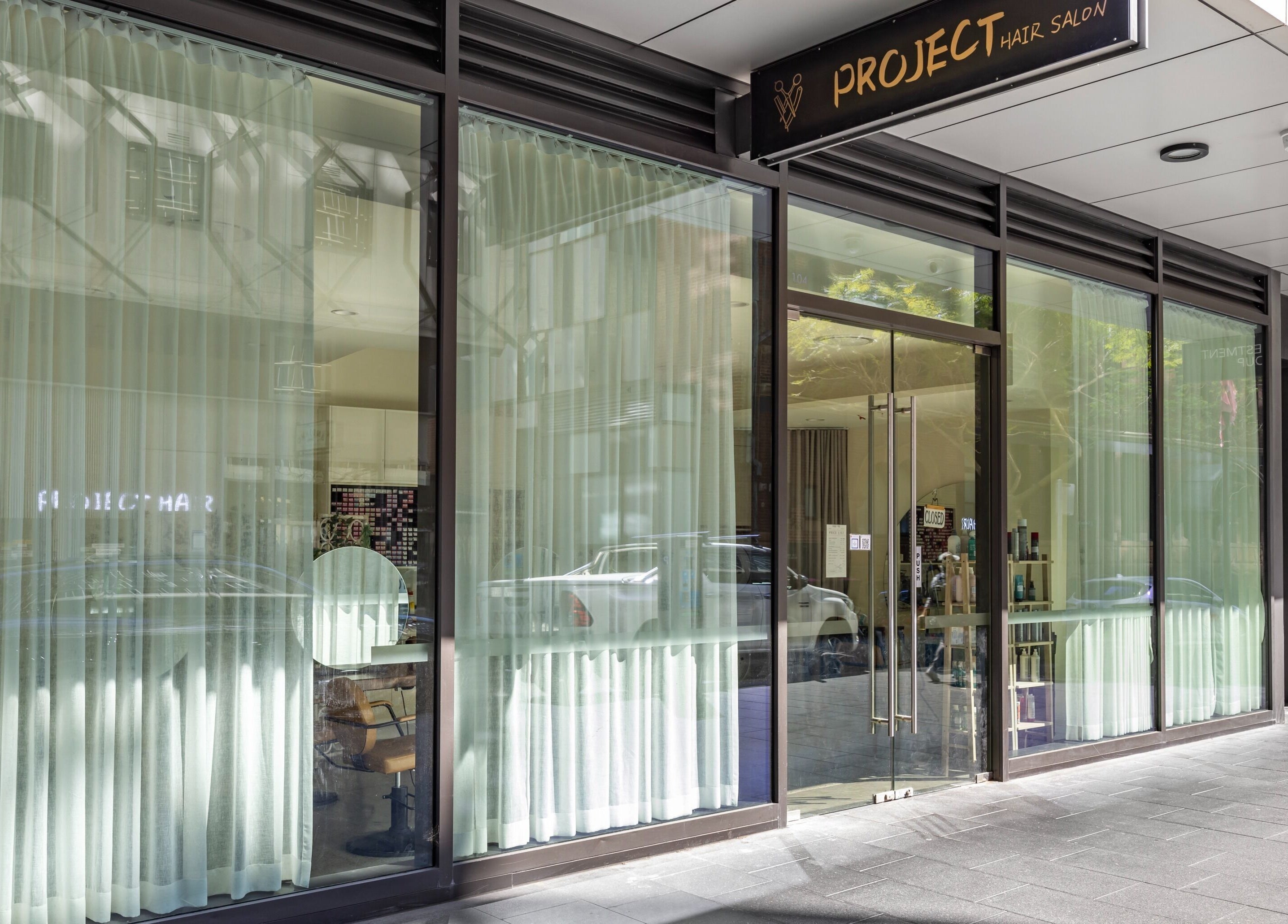 Front view of Project Hair Salon in Chippendale, NSW, AU showcasing sleek glass entrance.