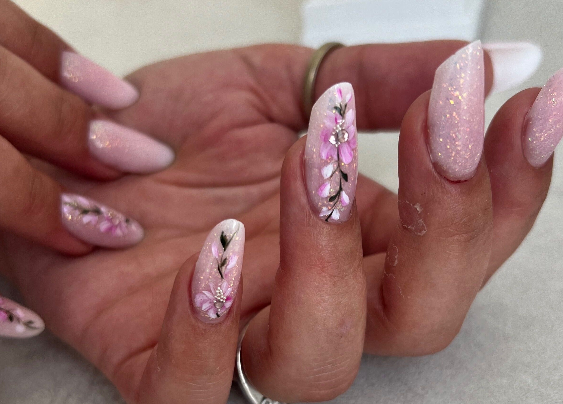 Γυναίκα με νύχια διακοσμημένα με ροζ λουλούδια στο Aurora Fiercely Feminine, Χαλκίδα, GR.