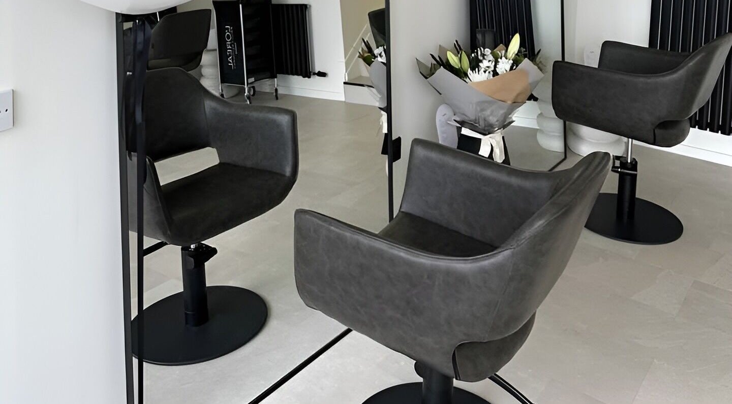 Modern styling chair at Claire Nelson Hair in Edinburgh, Scotland, GB, with sleek decor and floral accents.