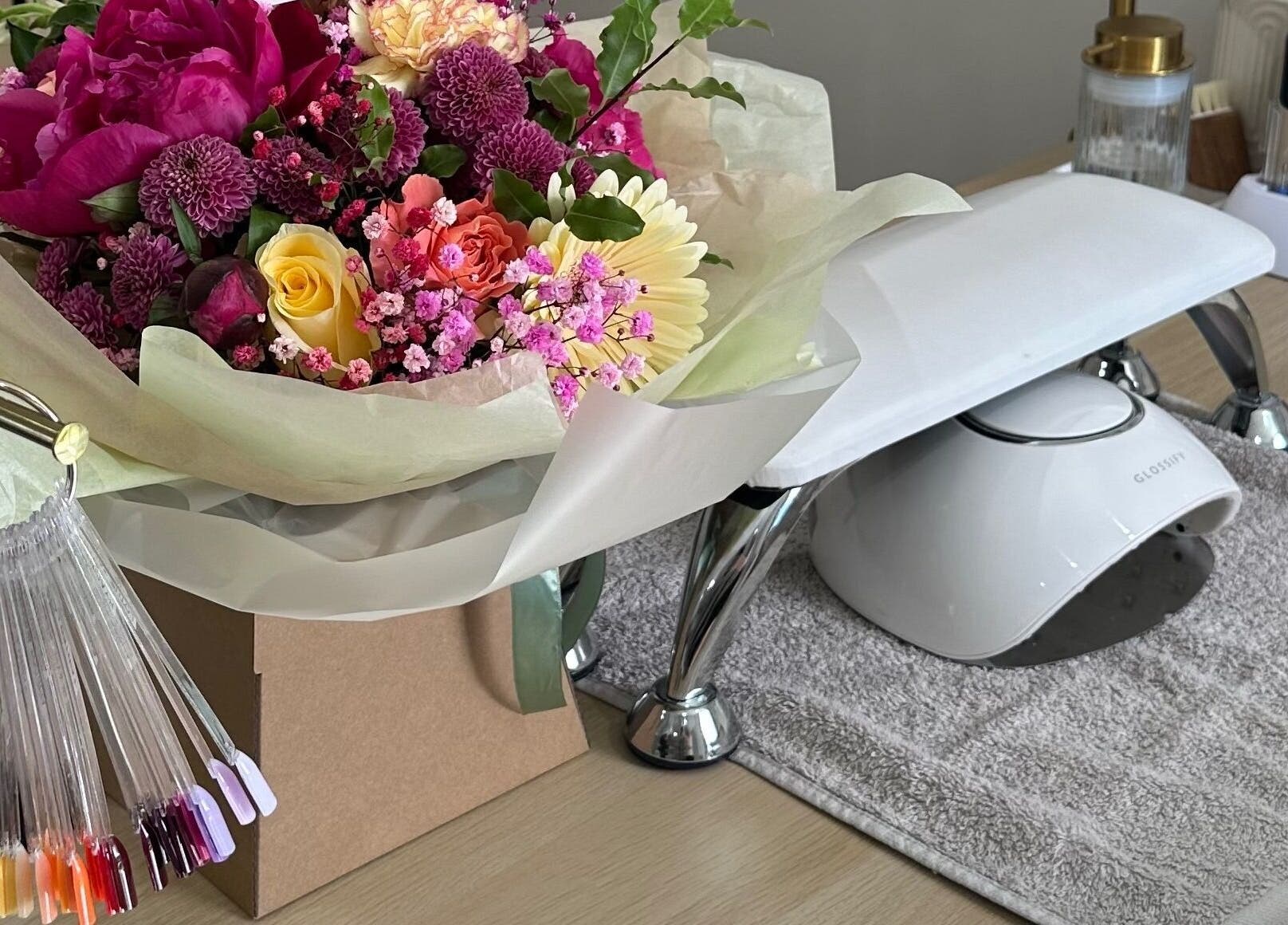 Manicure station with vibrant flowers at Nails by Ezme, Ashford, England, GB.