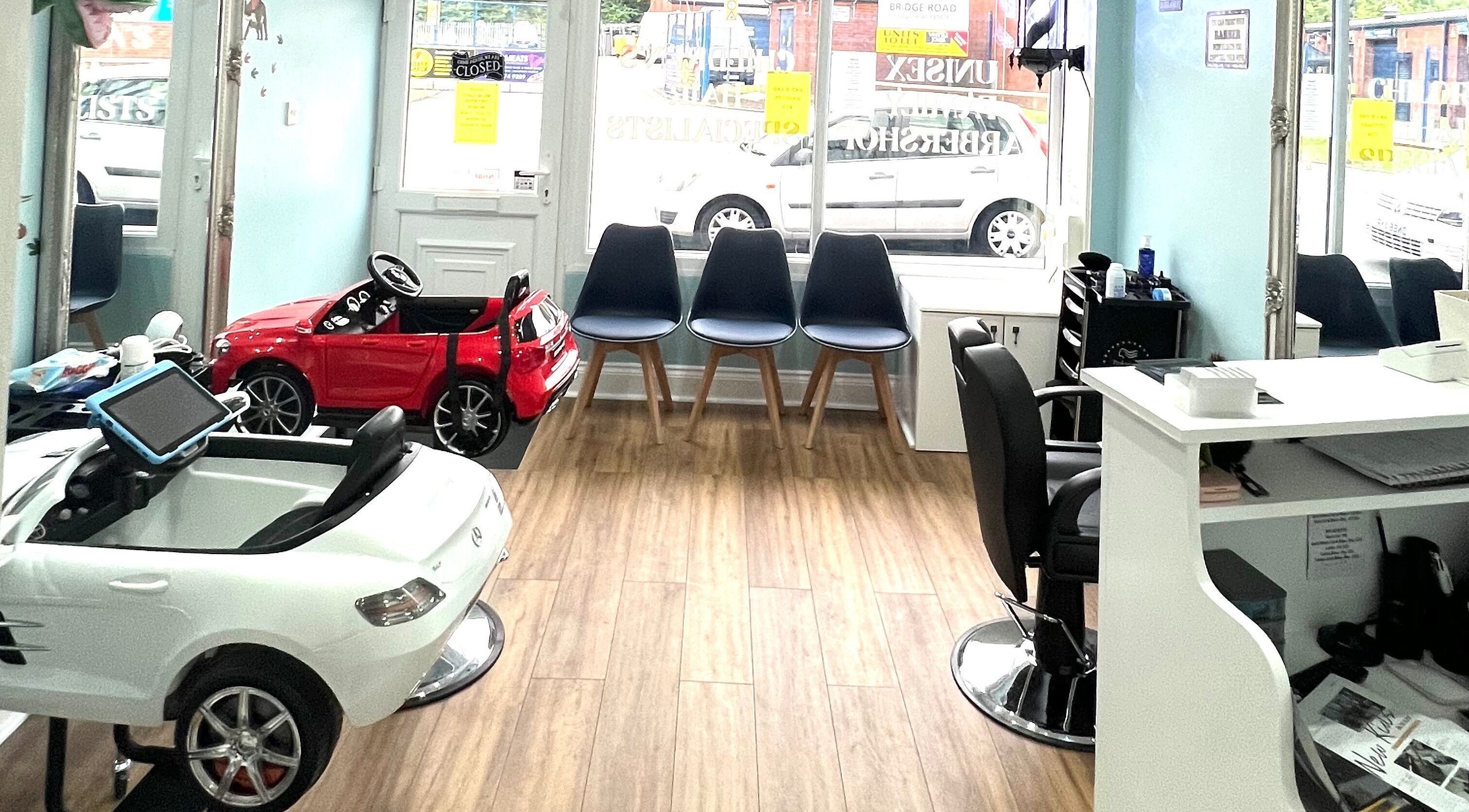Bright chic beauty area at Scruffs, Litherland, England, GB with chairs and toy cars.