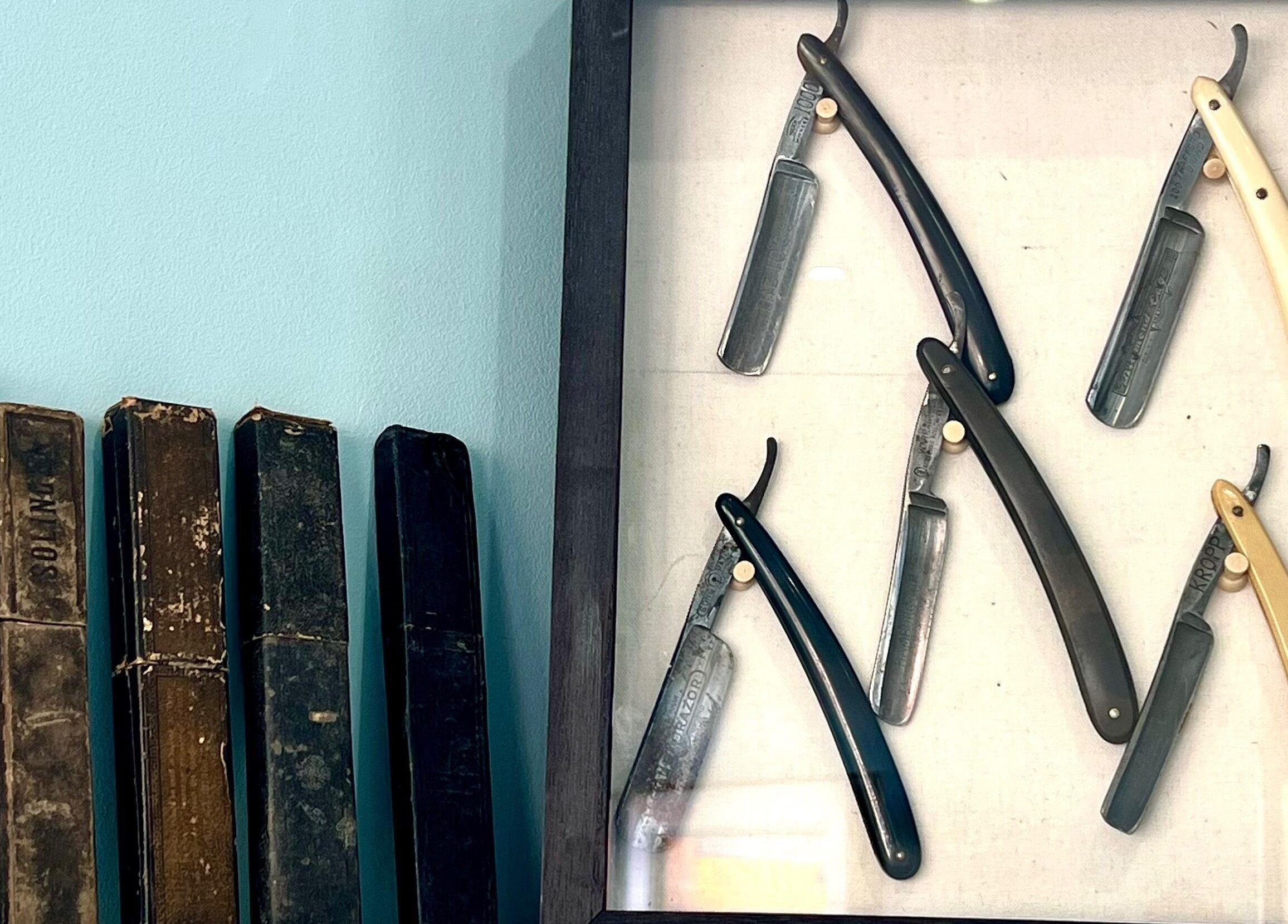 Vintage straight razors in a display at Scruffs, Litherland, England, GB showcase traditional grooming tools.