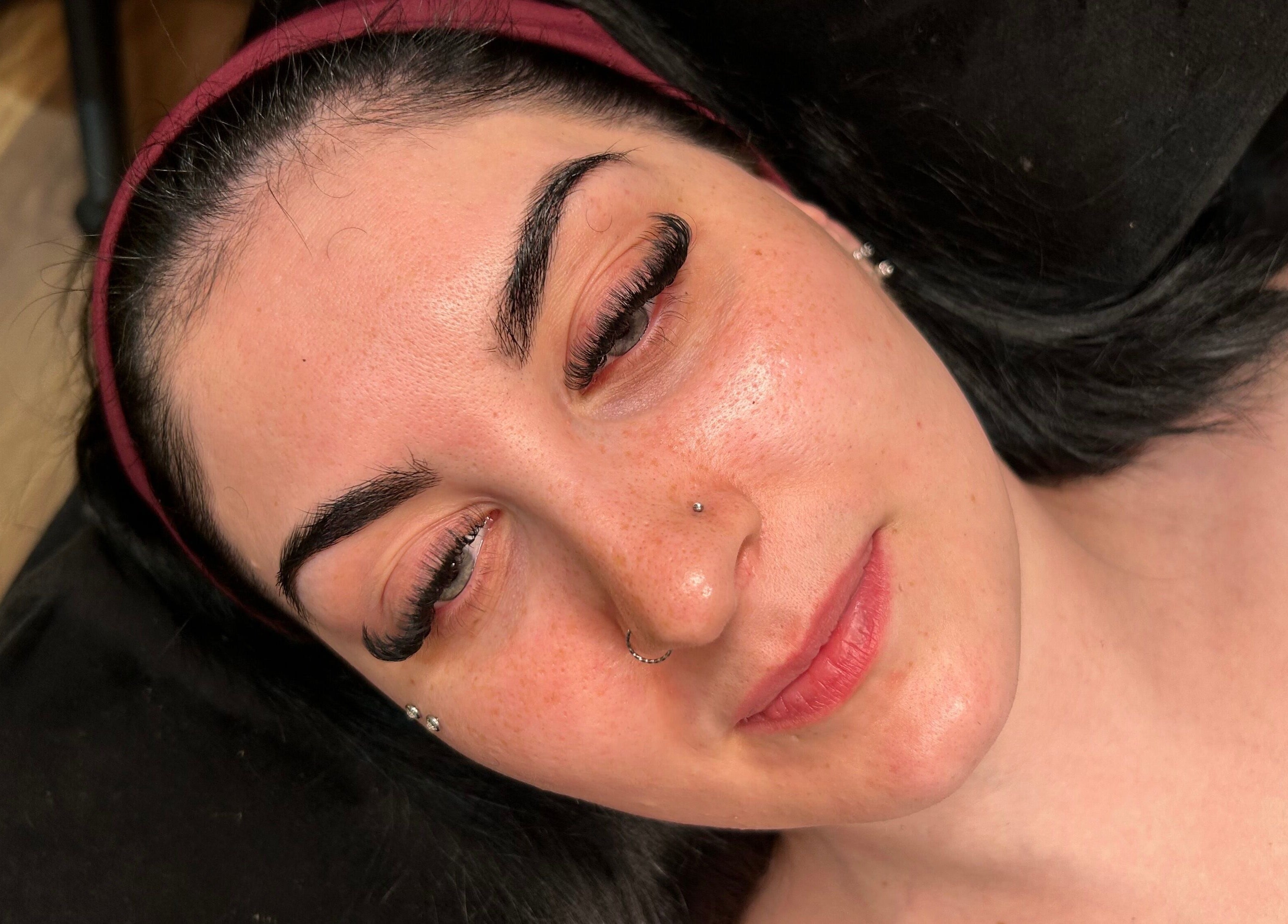 Woman with flawless skin and elegant lashes at Mfb Beauty, Harlow, England, GB.