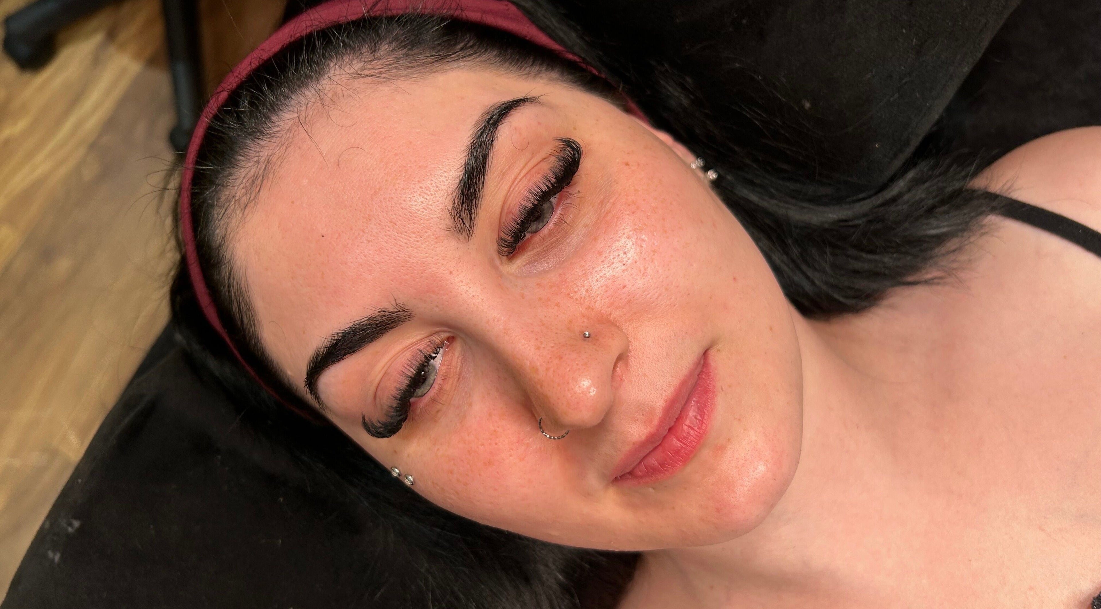 Woman with flawless skin and elegant lashes at Mfb Beauty, Harlow, England, GB.