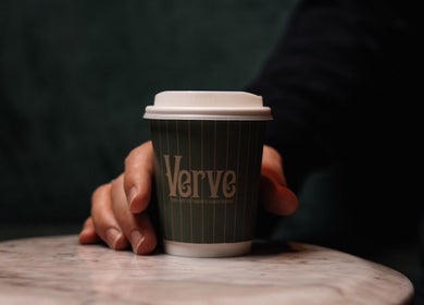 Hand holding a coffee cup labeled Verve at Verve Barbershop, Dubai, Dubai, AE.