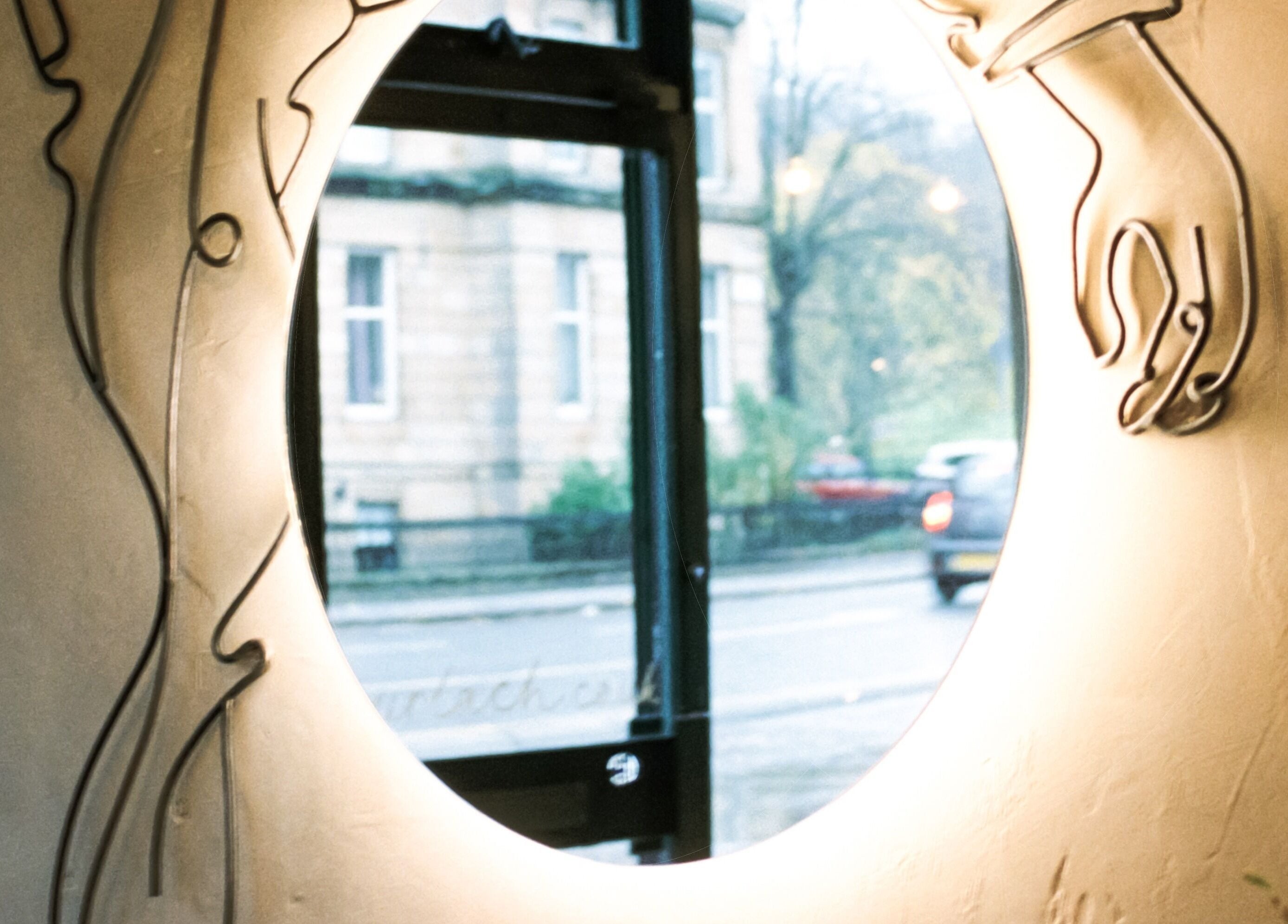 Stylish mirror with artistic hand design at Cùrlach, Glasgow, Scotland, GB, enhancing venue's unique aesthetic.