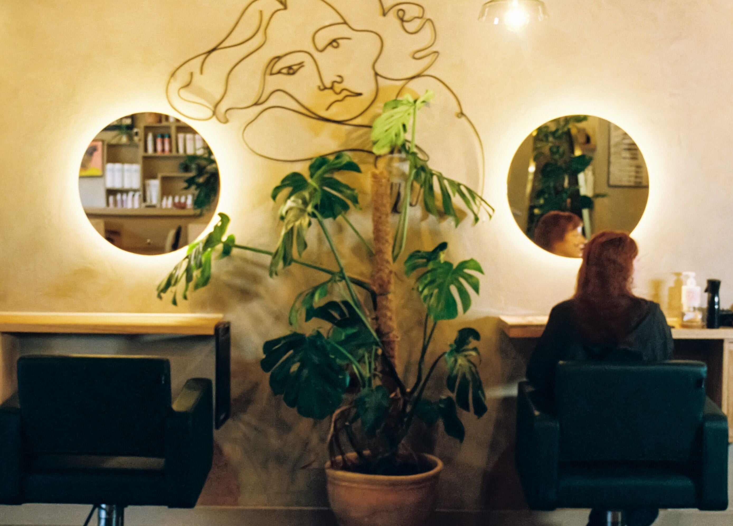 Cùrlach beauty venue in Glasgow, Scotland, GB featuring stylish decor with round mirrors and plants in the salon.