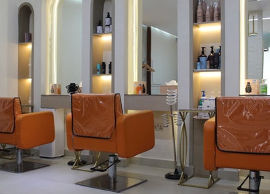 Luxurious chairs at Floral Beauty Lounge in Abu Dhabi, Abu Dhabi, AE with sleek, illuminated shelves.