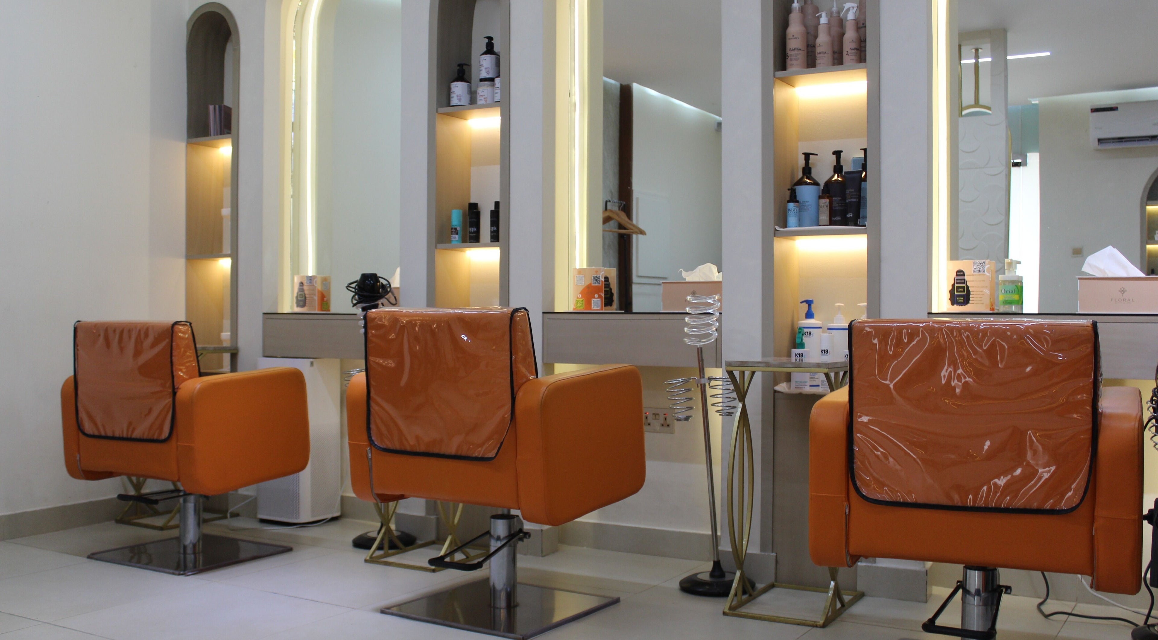 Luxurious chairs at Floral Beauty Lounge in Abu Dhabi, Abu Dhabi, AE with sleek, illuminated shelves.