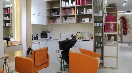 Modern salon interior at Floral Beauty Lounge, Abu Dhabi, AE, featuring stylish orange chairs and shelves.