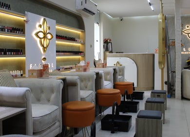 Relaxing nail salon area at Floral Beauty Lounge in Abu Dhabi, AE, featuring plush seating and nail polish displays.