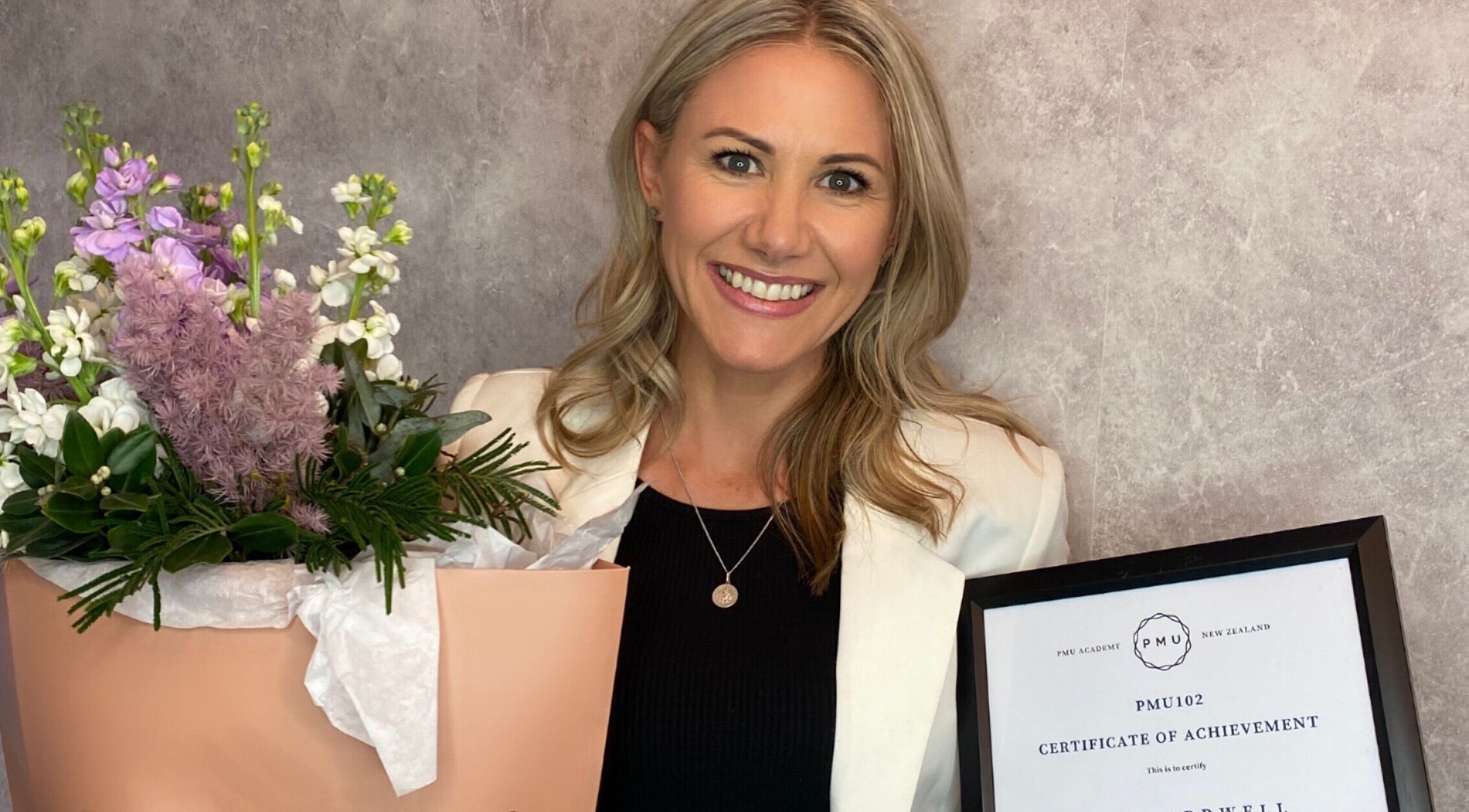 Award-winning staff at Tonic Beauté, Auckland, Auckland, NZ, holding flowers and a certificate.