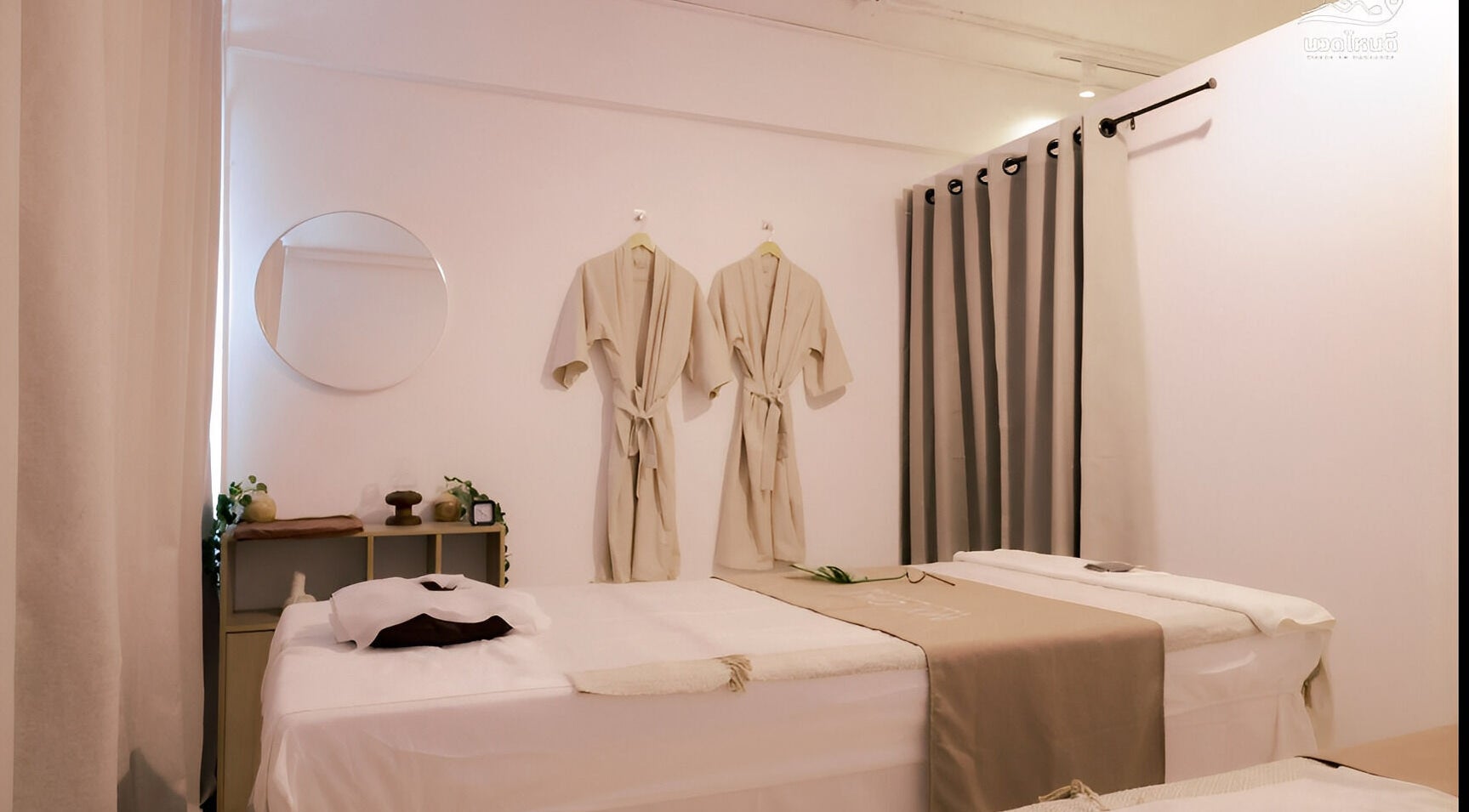 Calm massage room at My Day Thai Massage in Krung Thep Maha Nakhon, featuring elegant robes and a mirror.