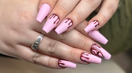 Unique pink nails with artistic red drip design at The Studio Nail Box, Cardiff, Wales, GB.